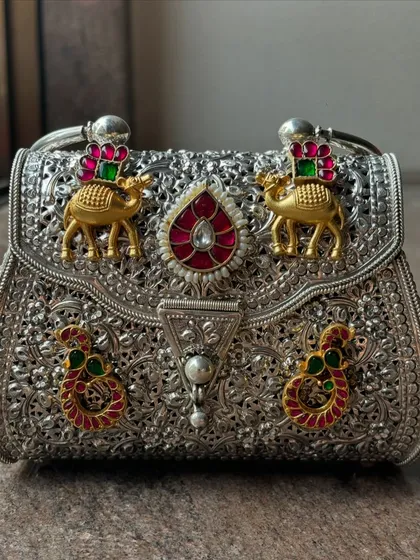 The perfect fusion of silver and colour. This clutch showcases how beautifully the gold-plated and enamel motifs stand out against the intricate, pure silver base.
