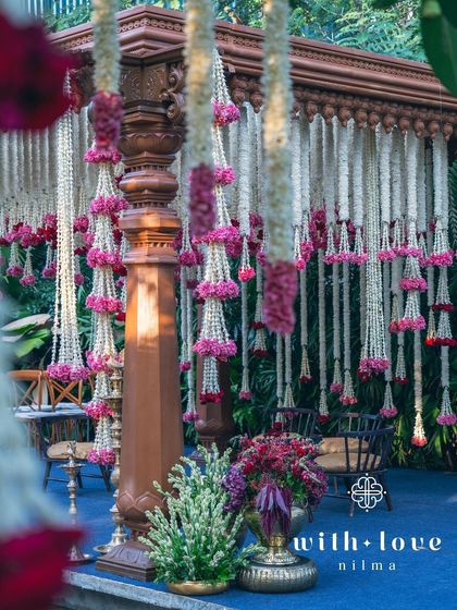 A close-up of the traditional floral garlands, or 'malas', used to decorate the summer wedding mandap.