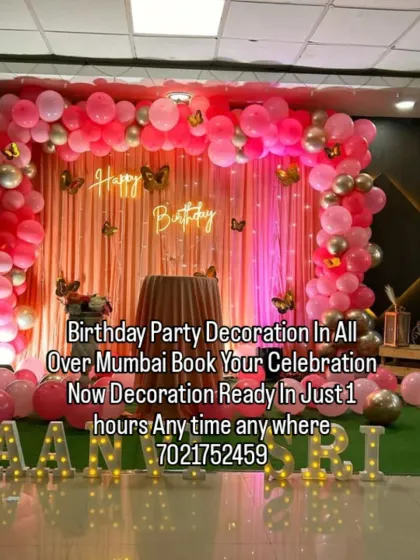 A glamorous pink and gold butterfly theme for Jaanvi's birthday. This setup features a pink curtain backdrop, a neon sign, and light-up marquee letters for a sparkling celebration.