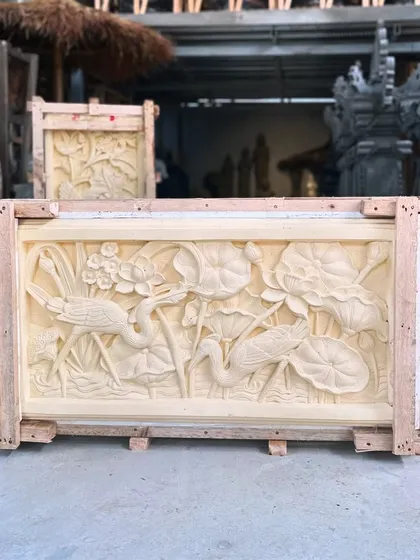 Transform a plain wall into a masterpiece. This intricate sandstone panel, hand-carved with a serene scene of lotuses and cranes, showcases the incredible skill of our Balinese artisans and brings natural artistry indoors.
