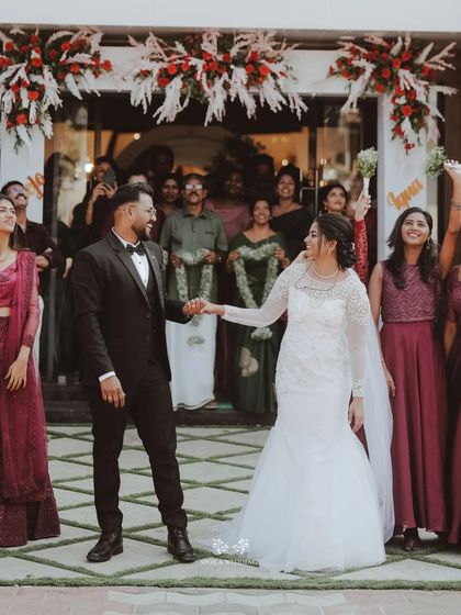 The bride and groom celebrating with their wedding party as they exit the ceremony, a moment of shared happiness.