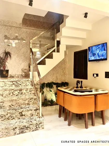 Another angle of the staircase area, highlighting the mix of textures from the marble stairs, wood paneling, and the greenery underneath, which adds a touch of nature.