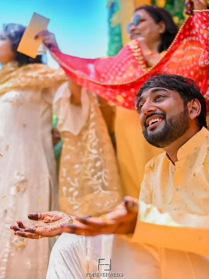 The groom's candid reaction during his Haldi ceremony. Capturing these genuine expressions of joy and surprise is what makes wedding photography feel alive.