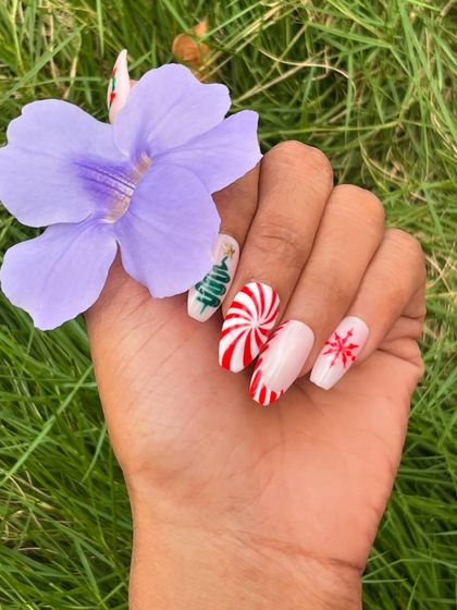 Getting into the Christmas spirit with this playful nail art. This set features a candy cane swirl, a hand-drawn Christmas tree, and a delicate snowflake design.