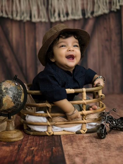 A happy little traveler ready for an adventure. This six-month-old boy's joyful smile is infectious in this rustic, travel-themed setup.