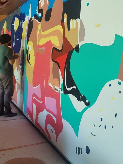 The team working together on the large-scale mural, showing the collaborative nature of our projects.