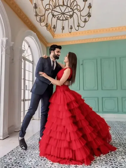 For that perfect pre-wedding shoot, I offer coordinated couple outfits. This dramatic red layered gown and complementary men's suit create a stunning visual, making your photos truly unforgettable.
