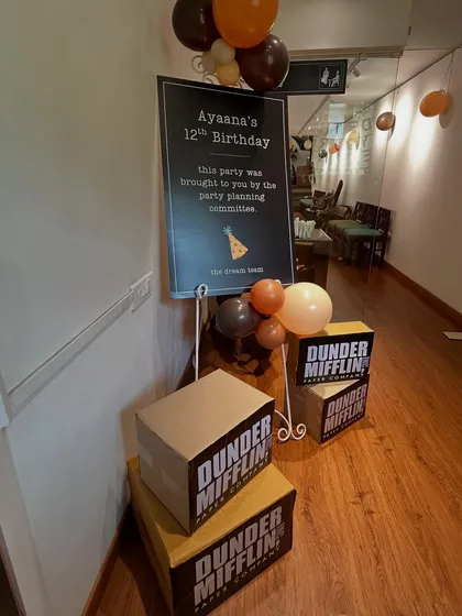 The welcome signage for 'The Office' themed birthday party. We used the show's classic font and humor, along with stacks of Dunder Mifflin paper boxes, to immediately immerse guests in the theme from the moment they arrived.