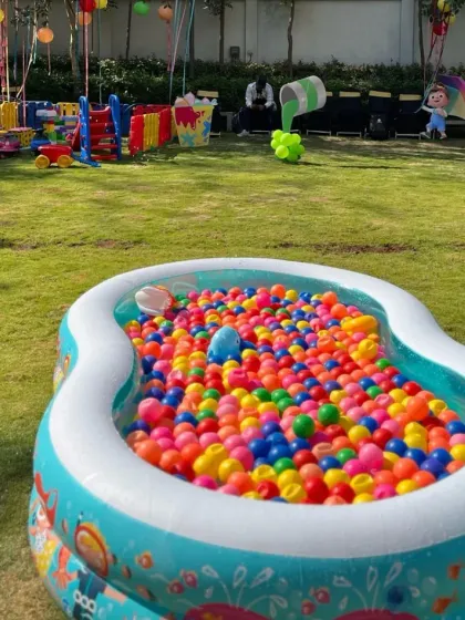 A wide view of an outdoor party setup featuring one of our large inflatable ball pits. We can set up our play equipment on grass or any suitable surface, transforming any space into a fun zone.