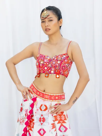 This is a classic e-commerce shot, providing a clear and direct view of the product. The model's confident pose and the clean white background ensure that the focus remains entirely on the colorful and detailed two piece outfit.