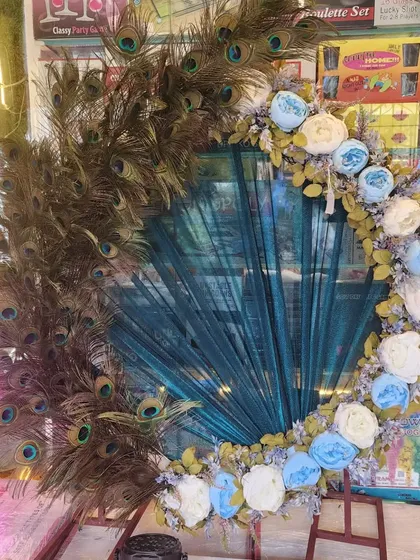 This is one of my signature Ganapati decoration frames, featuring a stunning arrangement of real peacock feathers and artificial flowers. It’s a unique and elegant backdrop that brings a divine touch to your festival celebrations at home.