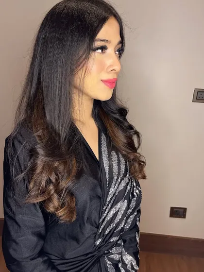 A side profile showing the soft waves in her hair and the clean lines of the makeup.