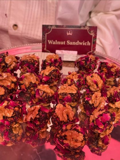Our Walnut Sandwich is a healthy and delicious sweet treat. It features a rich filling of dates and nuts, coated with rose petals and sandwiched between two walnut halves.