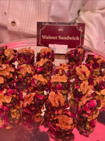 Our Walnut Sandwich is a healthy and delicious sweet treat. It features a rich filling of dates and nuts, coated with rose petals and sandwiched between two walnut halves.