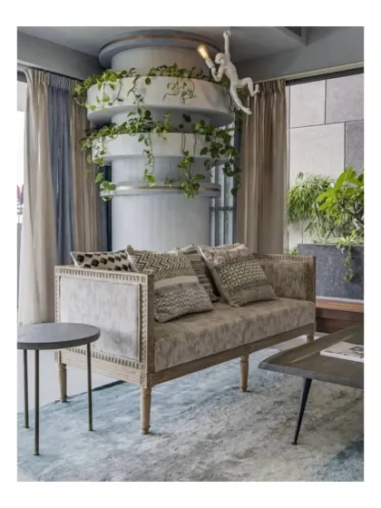 This living area at Peninsula Heights features a unique planter integrated into a structural column. The trailing plants soften the modern architecture and draw the eye upward, adding a dynamic vertical element to the room.