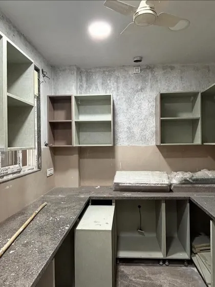 The kitchen of a CR Park project during the interior finishing stage. The modular cabinets are being installed, and the granite countertop is in place, showing the layout of the U-shaped kitchen.