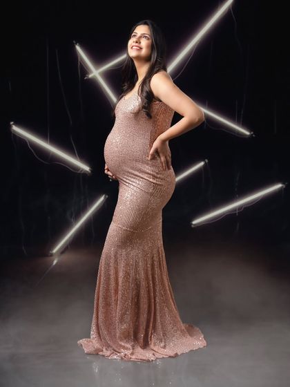 A powerful pose showing the beautiful silhouette of pregnancy, enhanced by the glow of abstract neon lights.