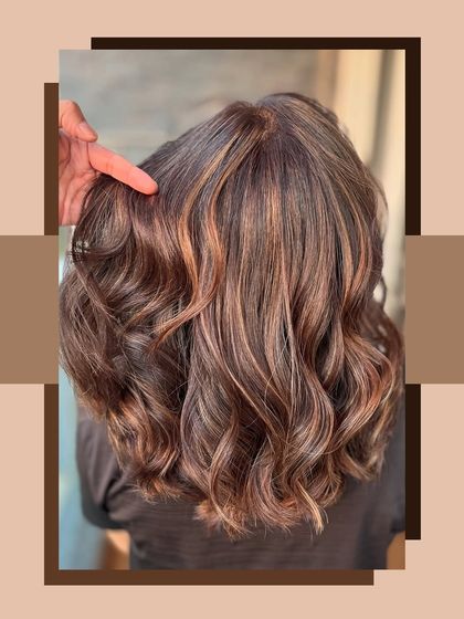 A close-up of a rich chocolate brown base with perfectly blended caramel balayage. The soft waves highlight the seamless transition between the colours.