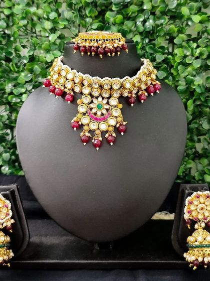 A beautiful kundan choker set with red beaded drops, perfect for adding a touch of color.