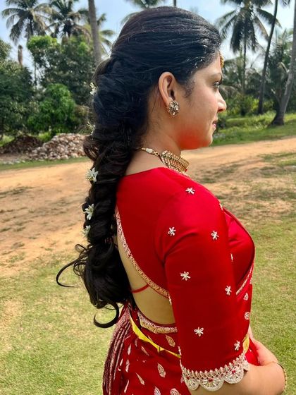 A side profile of Amulya in her red saree, looking absolutely stunning.
