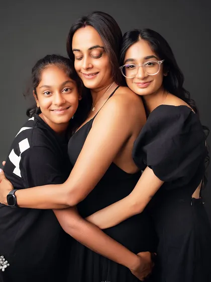 A mother's embrace. This beautiful portrait of a mom hugging her two daughters is a powerful image of love and support, captured in a simple and elegant style.