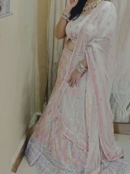 A full-length view of the client in the white and pink lehenga, showing how perfect it is for a house function or daytime event.