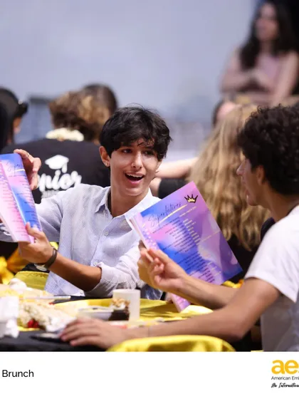 A senior excitedly shows off his new yearbook during the Senior Brunch. This event, hosted by our Parent School Association, is a time for students to sign yearbooks and celebrate together.