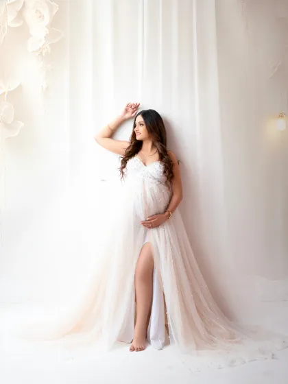 A quiet moment of contemplation. This portrait uses soft lighting and a simple white curtain backdrop to create an intimate and timeless feel.