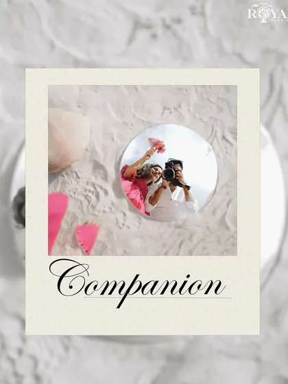 A creative flat-lay style shot showing a reflection of the couple in a mirror, surrounded by sand and flowers.