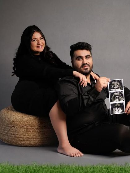 A fun studio portrait where the dad-to-be holds up the sonogram pictures for the camera.