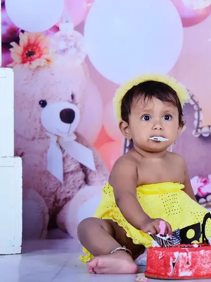 A cute moment from a cake smash, with frosting on the baby's face.