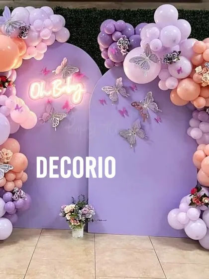 A variation of the butterfly theme, this baby shower setup uses a rich purple palette. The "Oh Baby" neon sign adds a modern glow, while glittery butterfly cutouts on the backdrop create a sparkling effect.