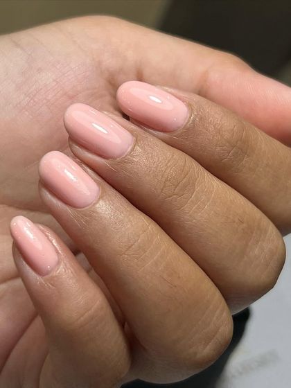 The beauty of a simple, clean manicure. This look was achieved with meticulous cuticle work using an e-filer and a strengthening gel overlay in a natural pink shade.