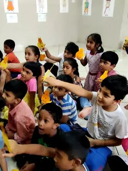 A wide shot of the children's puppetry class, showing everyone busy with their creations. The room is always buzzing with energy and excitement during these sessions.