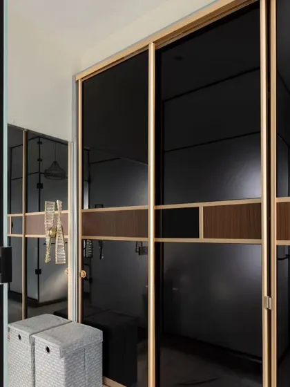 This walk-in closet and vanity area exudes luxury. I used a combination of black tinted glass sliding wardrobes and a bright, white vanity with marble-patterned walls to create a sophisticated and highly functional dressing space.