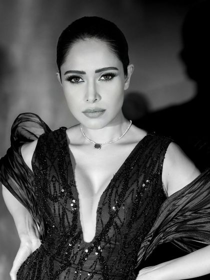 A classic black and white beauty shot of Nushrratt Bharuccha. The lighting is carefully sculpted to highlight her features, creating a flawless and glamorous look.