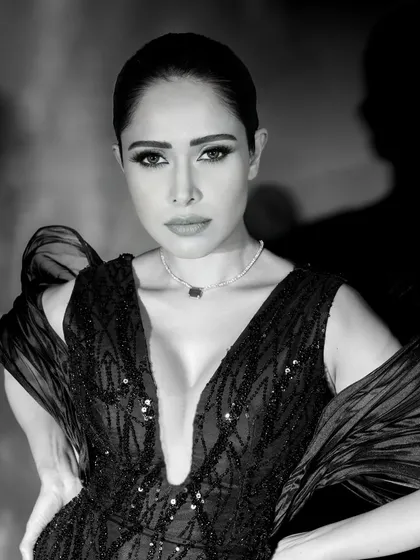 A classic black and white beauty shot of Nushrratt Bharuccha. The lighting is carefully sculpted to highlight her features, creating a flawless and glamorous look.
