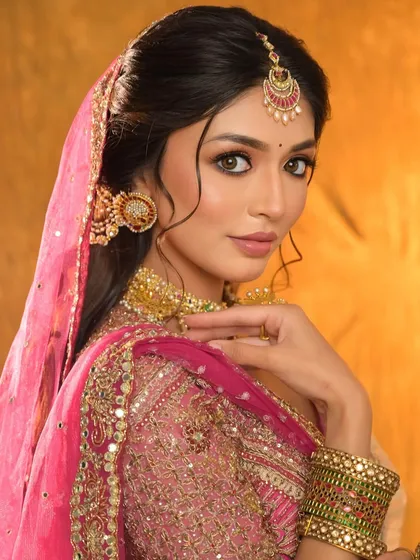 A classic bridal pose, showcasing the intricate details of the jewellery and the perfectly styled hair.