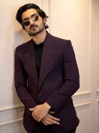 A full look at the wine-colored tuxedo. The unique wide lapel and single-button closure create a modern, fashion-forward silhouette that's perfect for a cocktail party or sangeet.