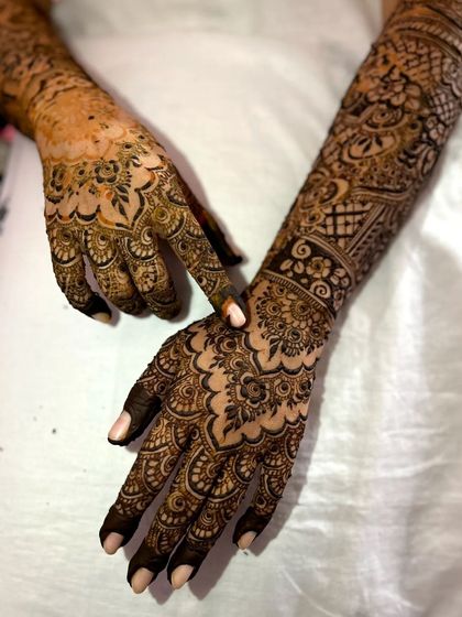 An elegant pose showing the intricate details on both the front and back of the hands for this complete bridal mehendi.