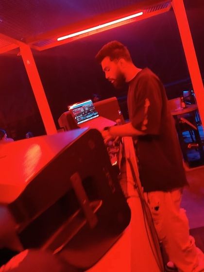 A candid shot of me working the decks under the intense red lighting at Sunburn Union.