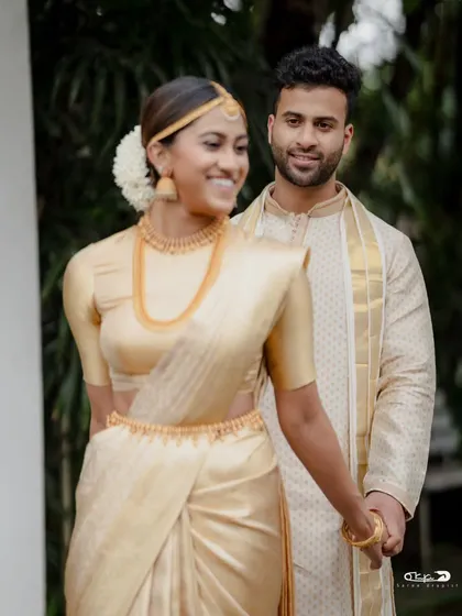 A perfect match. I draped the groom in a classic kasavu mundu and angavastram that beautifully complemented the bride's golden saree, creating a coordinated and elegant look for their special day.