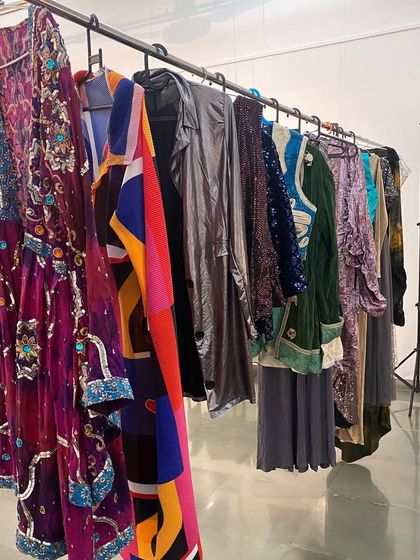A rack of colorful costumes used for the 'Pop Up Studio' event during the 'Southern Stars' exhibition.
