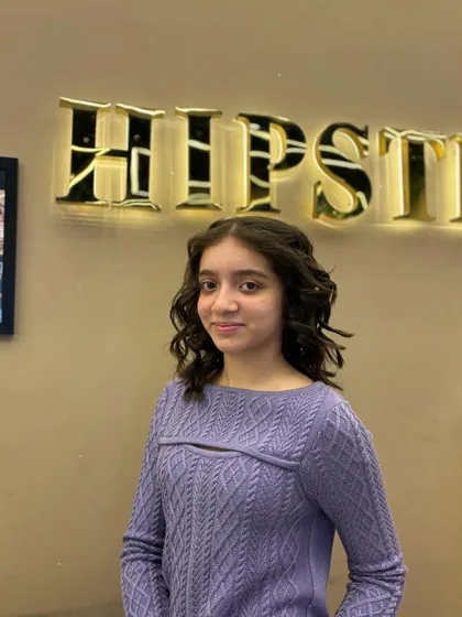 A cute and stylish look for a young client, with her hair styled in soft, face-framing curls.