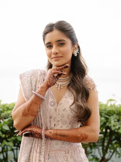 A solo portrait of the bride-to-be. This image showcases her intricate henna and the beautiful details of her pastel lehenga.