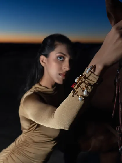 A model poses with a horse against a dramatic sunset sky for a jewelry brand campaign. The "golden hour" light at our facility creates a magical and luxurious feel for product and fashion shoots.