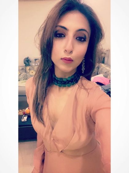 A close-up of my look, featuring a statement green beaded choker that adds a pop of color to the soft pink dress.