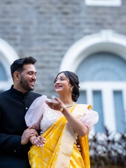 A beautiful, interactive shot of the couple enjoying their pre-wedding photoshoot. Her expressive gesture and their shared gaze make this a lively, engaging portrait.