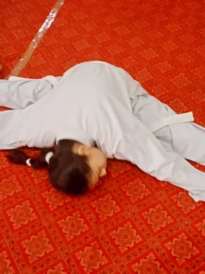 Flexibility is a key component of our belt tests. This student is demonstrating a full split, a result of dedicated stretching.