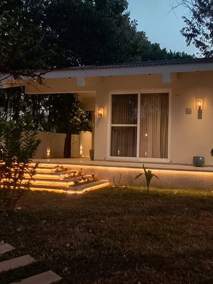 Conceptualized around existing trees, our Amberle resort in Yelagiri preserves the site's natural beauty. This evening view shows the inviting glow of the villa, creating a delightful tension between exploring the grounds and relaxing indoors.